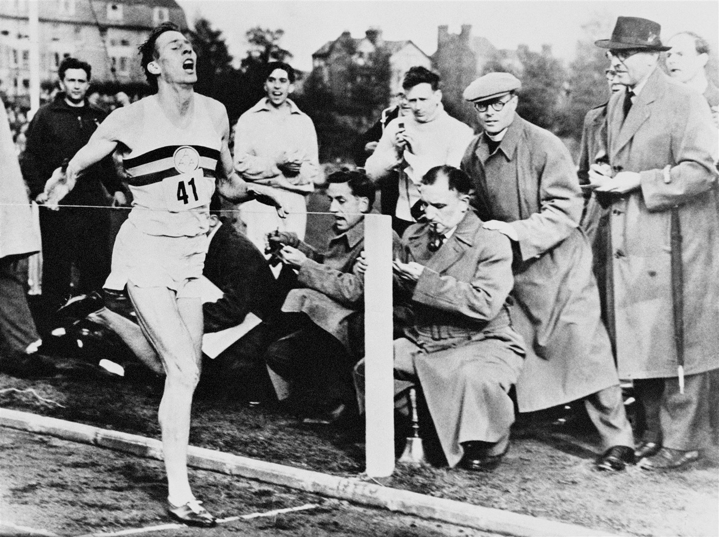 Medical student Roger Bannister running the world’s first four-minute mile during an athletics meeting in Oxford in 1954 (PA)