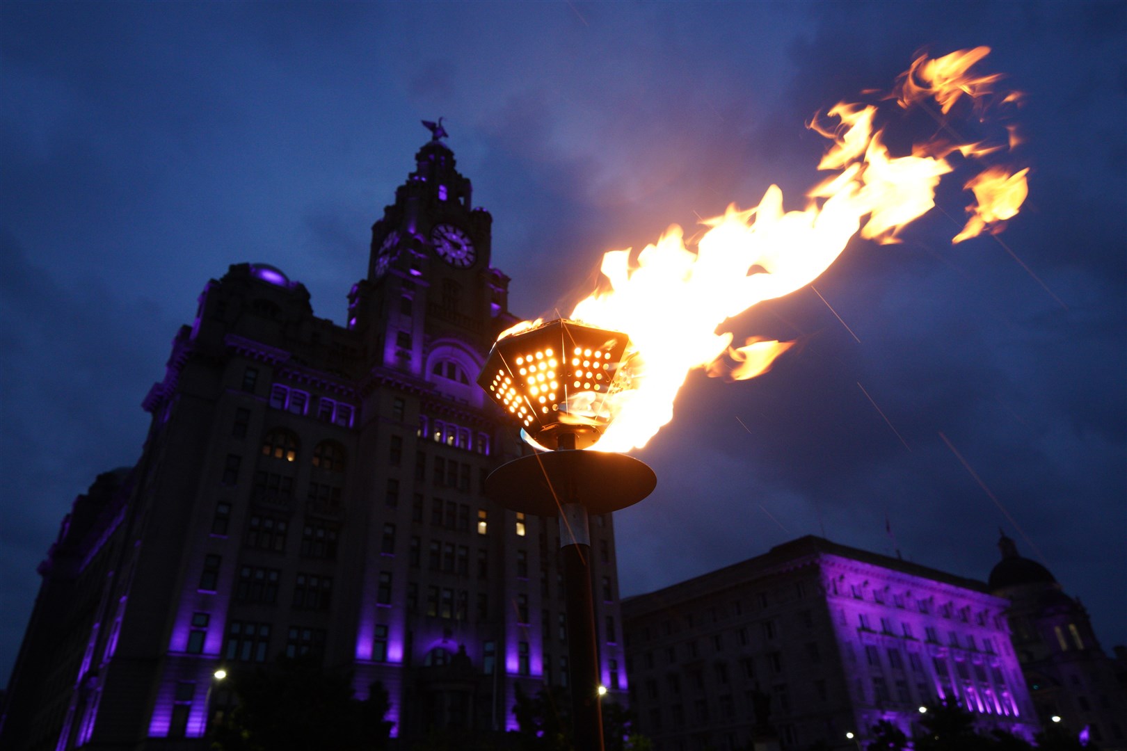 Beacons are lit outside the Royal Liver Building in Liverpool (Peter Byrne/PA)