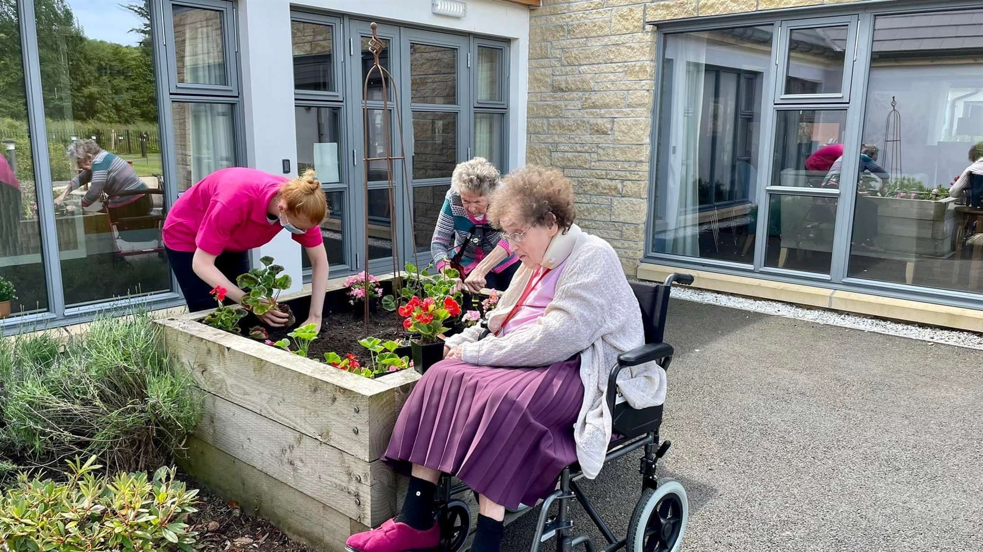 Residents and staff planting some of their donated flowers.