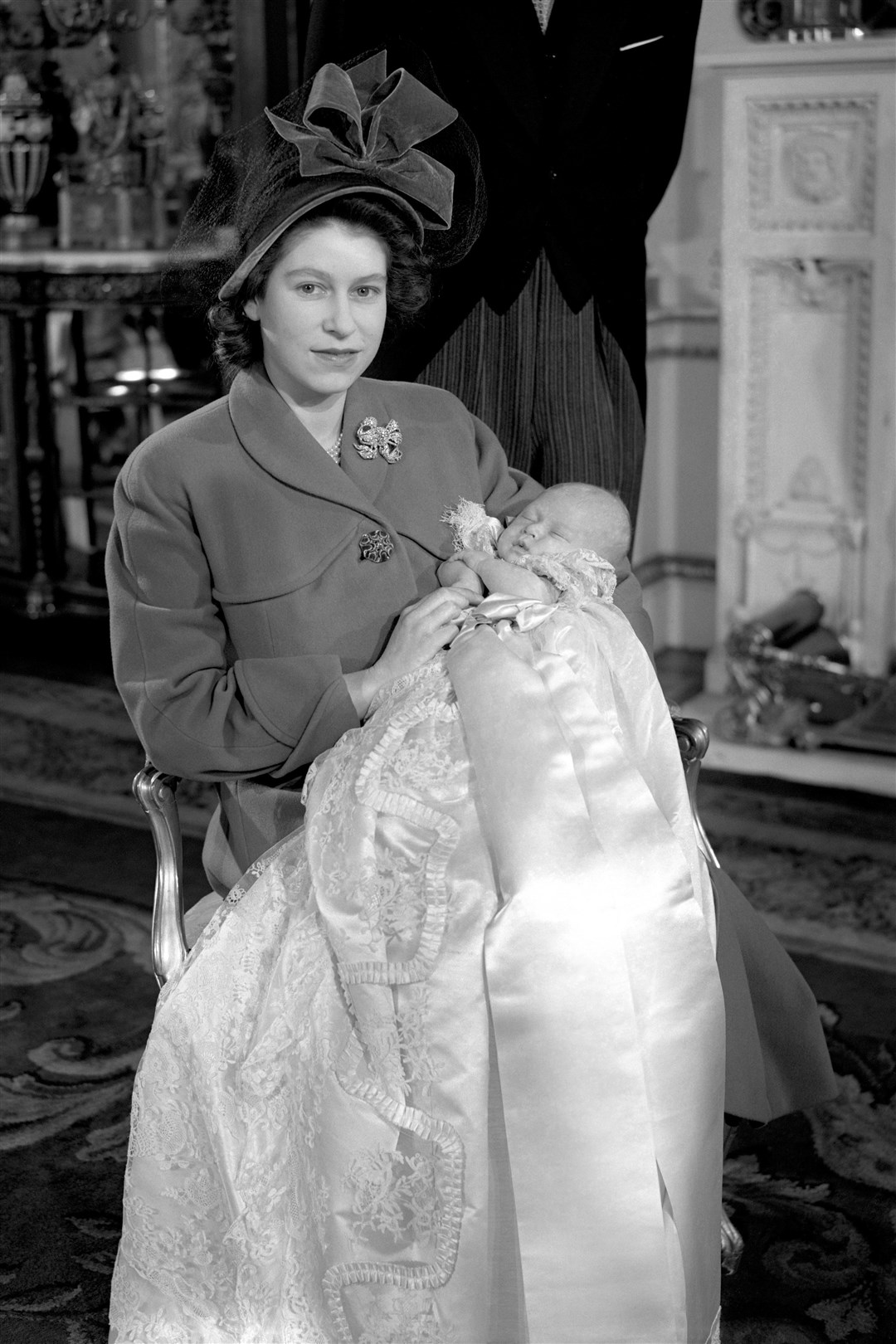 Princess Elizabeth, later Queen Elizabeth, holding her baby son Prince Charles at his christening in 1948 (PA)