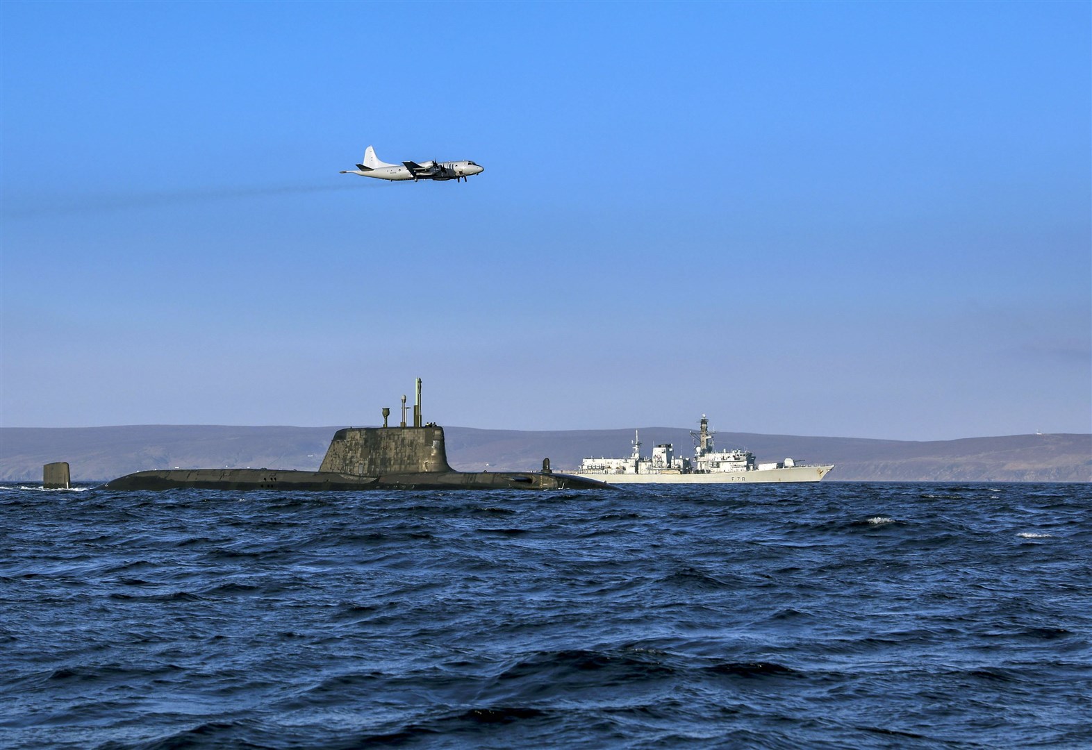 An Astute class nuclear submarine in company with the Type 23 frigate HMS Kent being over flown by a German Navy P3 maritime patrol aircraft during a previous operation Joint Warrir exercise.