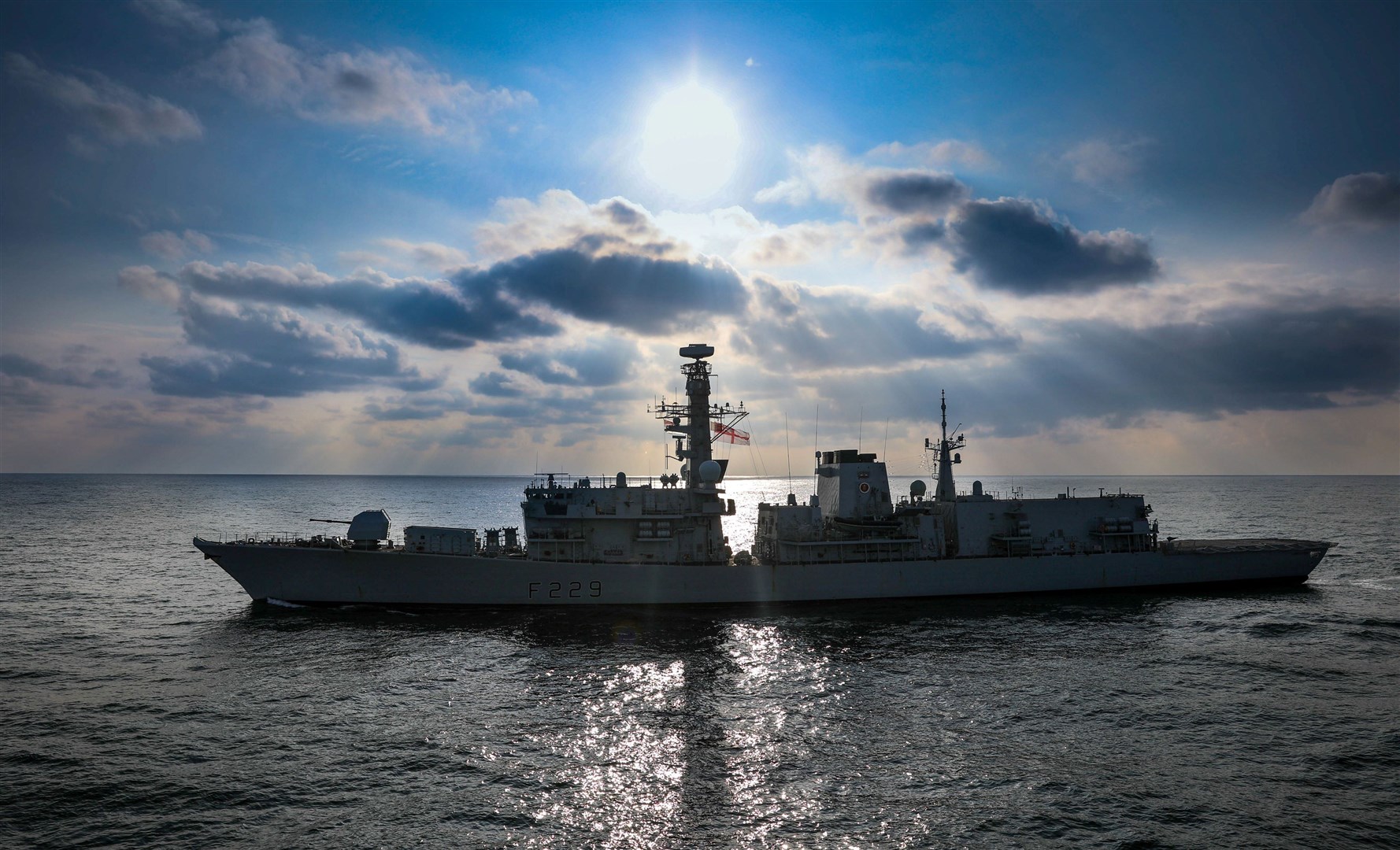 HMS Lancaster, a Royal Navy Type 23 frigate silhouetted against the setting sun off the Hebrides Isles during a previous Exercise Formidable Shield.