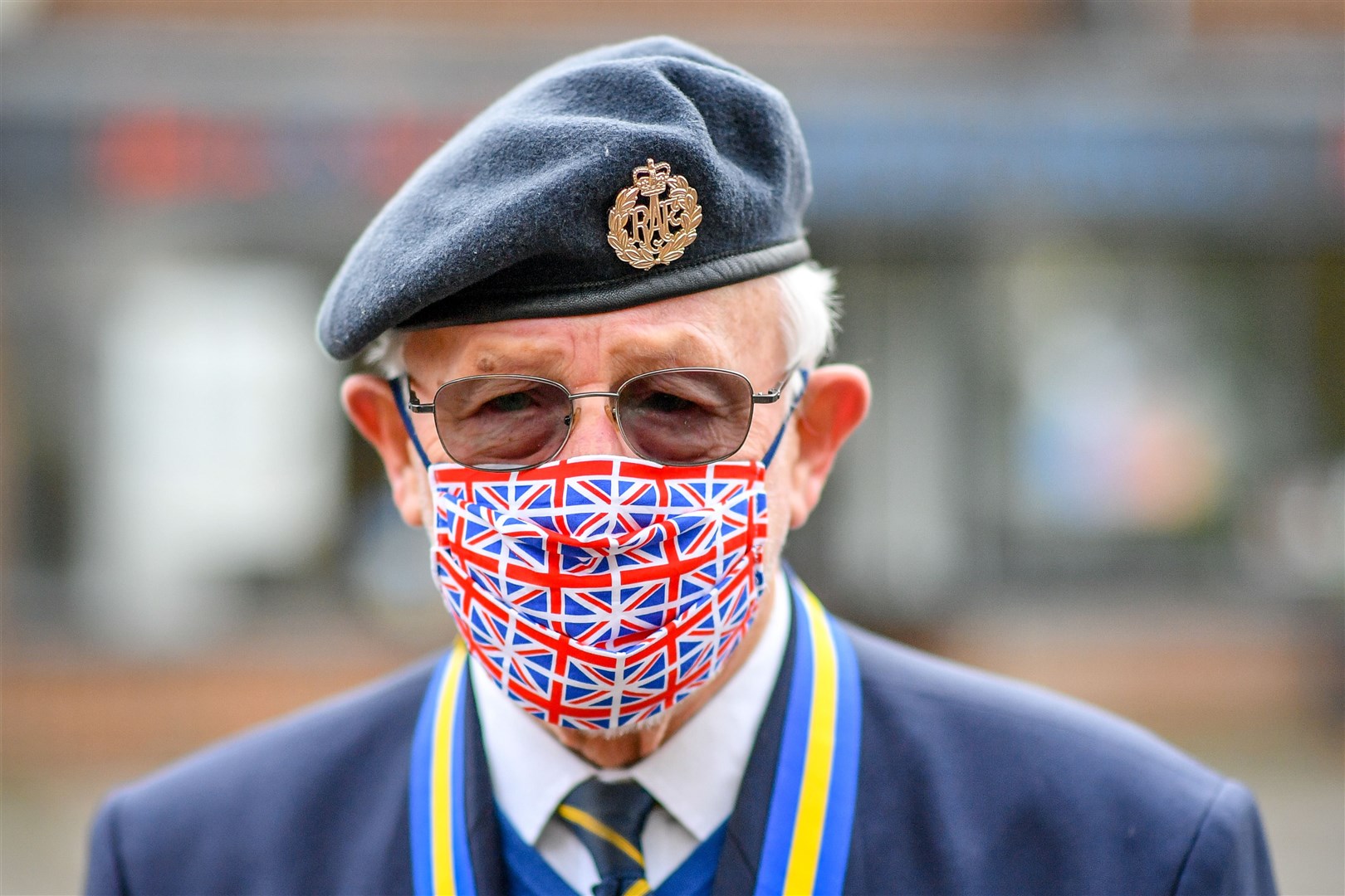 Ex RAF serviceman Tom Blundell wears a Union flag face mask at the war memorial in Royal Wootton Bassett (Ben Birchall/PA)
