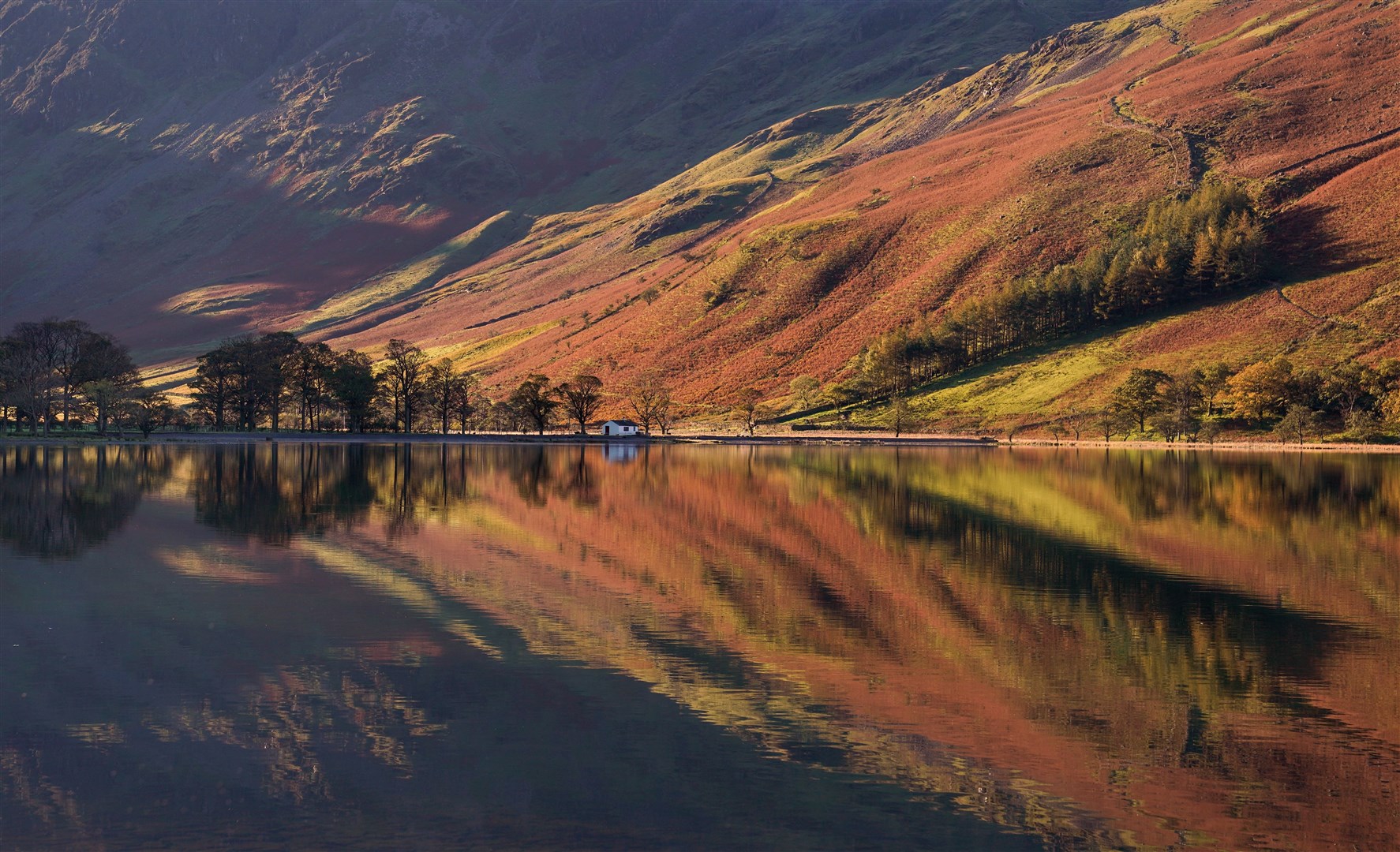 Autumnal reflections in Lake Buttermere (Owen Humphreys/PA)