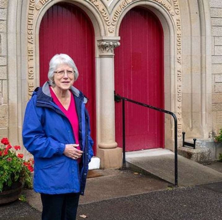 Ann Ralston in front of the main doors to Inverallan Church.