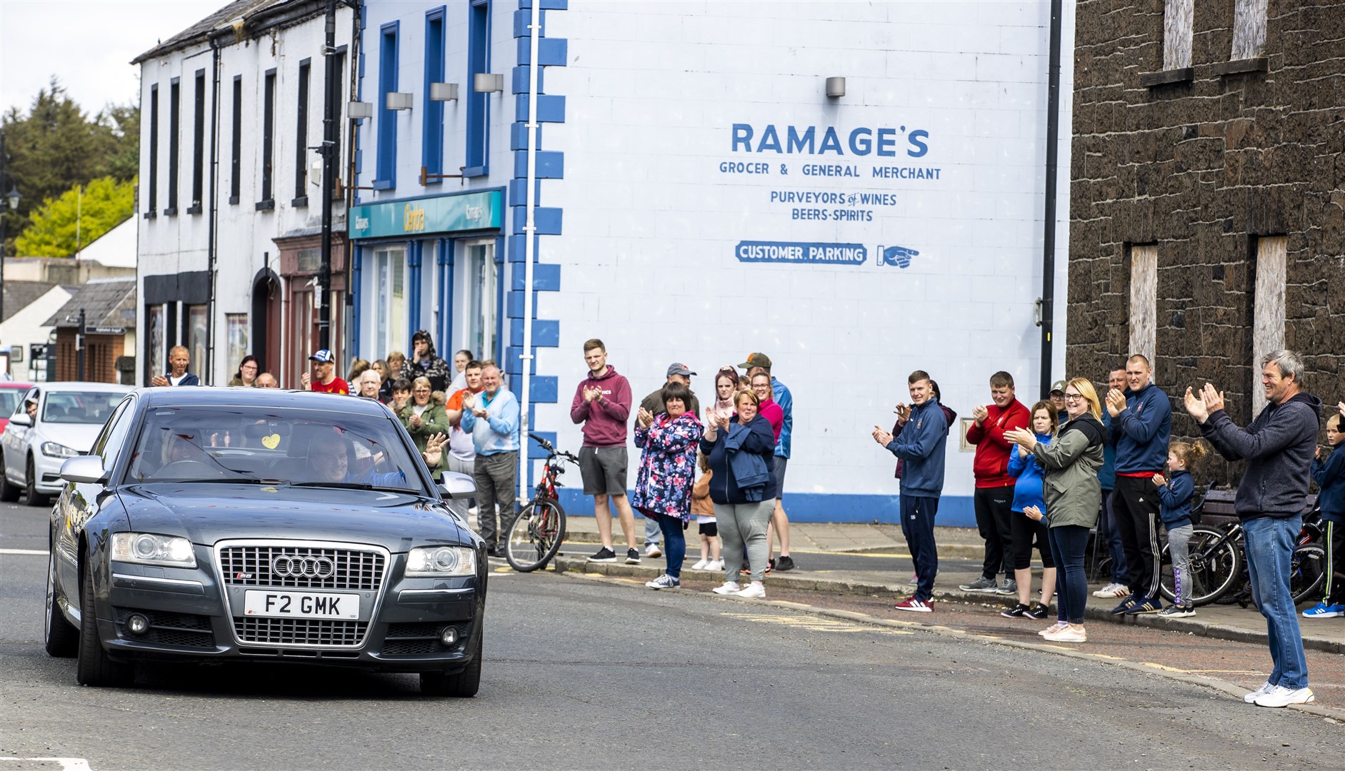 Geoffrey McKillop (passenger seat of car) shows his gratitude as he waves to well wishers in Co Antrim, after being discharged from Causeway Hospital (Liam McBurney/PA)