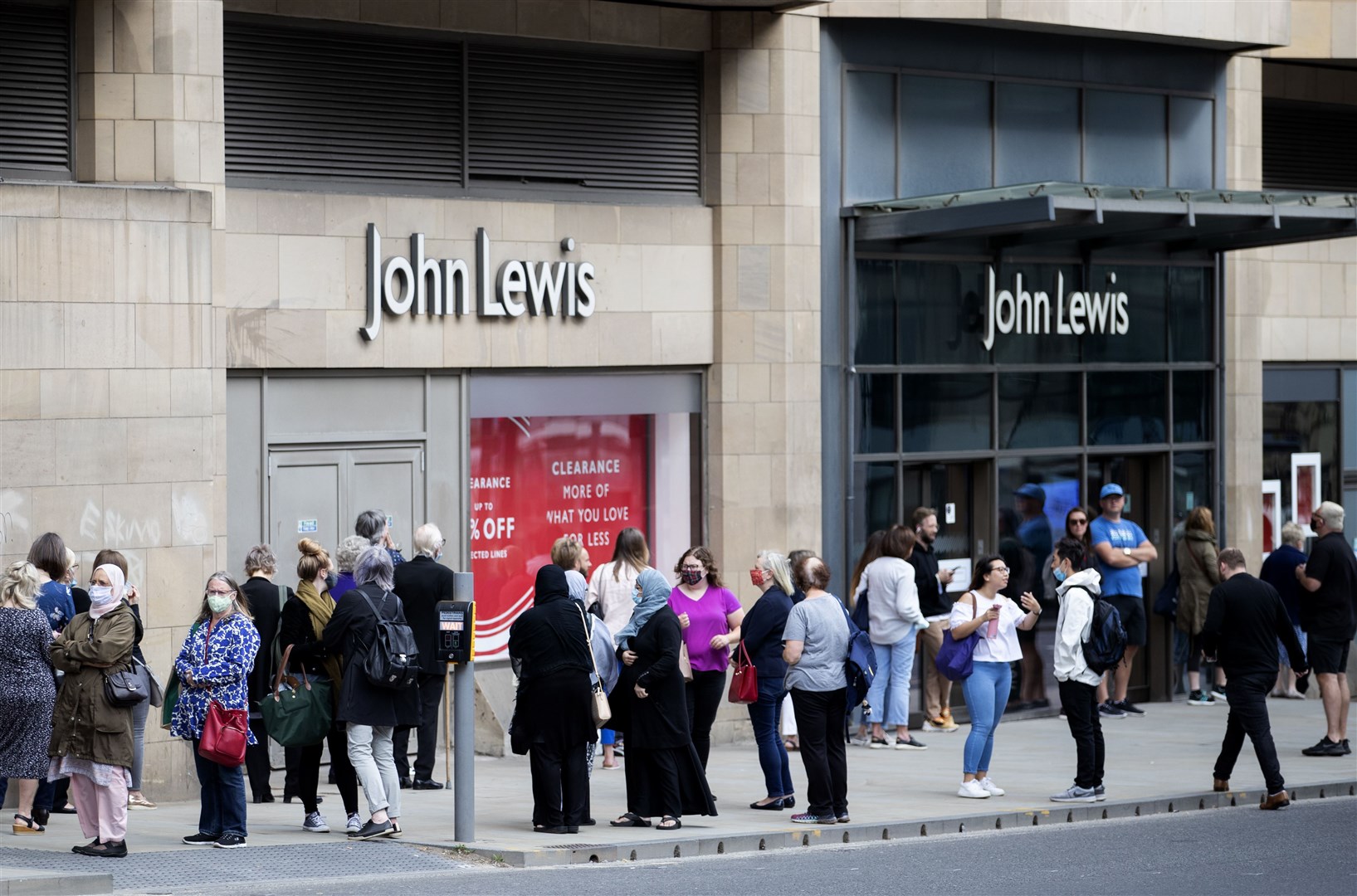 People queue outside the John Lewis department store in Edinburgh as it re-opened its doors in July (Jane Barlow/PA)