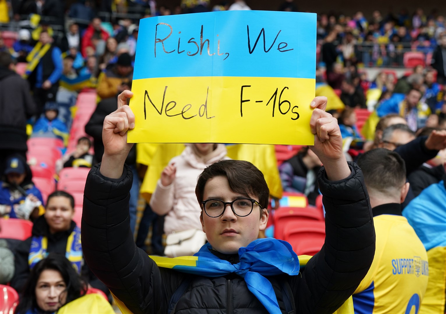 A Ukraine fan in the stands holds up a banner reading ‘Rishi, We Need F-16s’ (Nick Potts/PA)