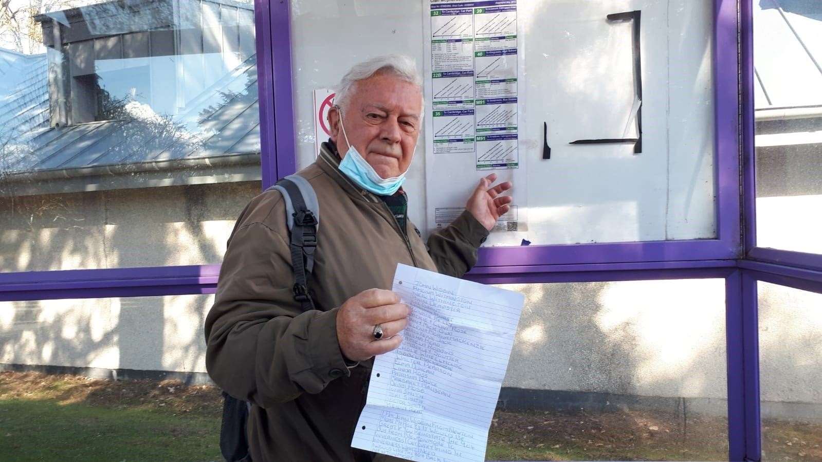 Newtonmore resident John Wiggin at the bus stop with the petition.
