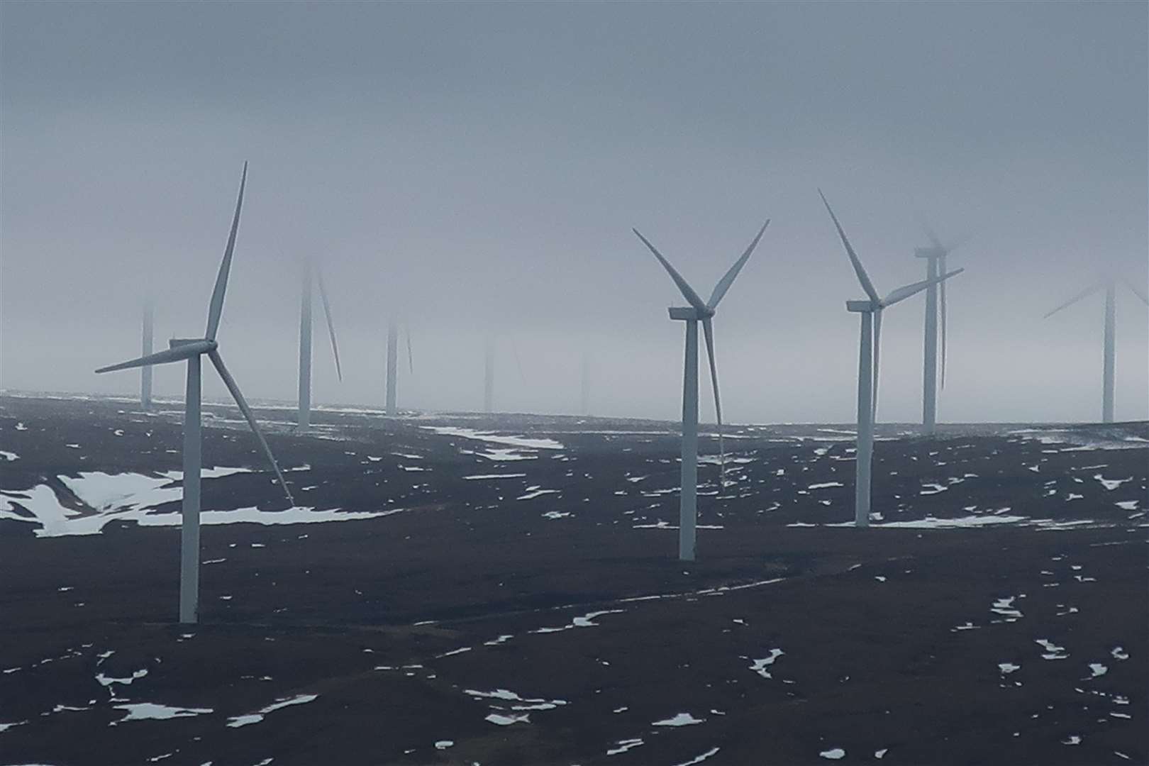 The turbines of Dunmaglass wind farm under a low blanket of cloud.