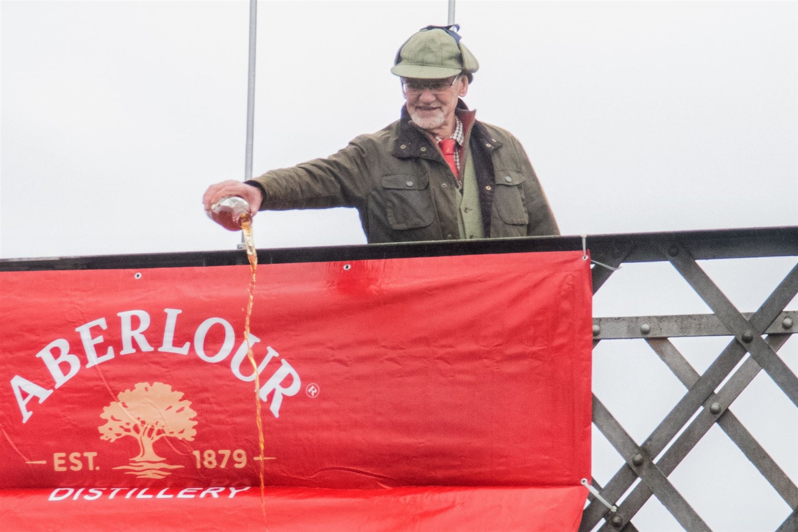 Guest of honour John Anderson pours a bottle of Aberlour Whisky into the flowing waters. Picture: Daniel Forsyth.