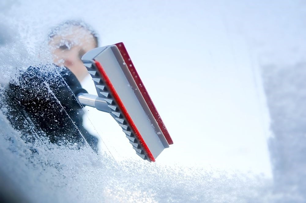Scraping ice off a car window (stock image).