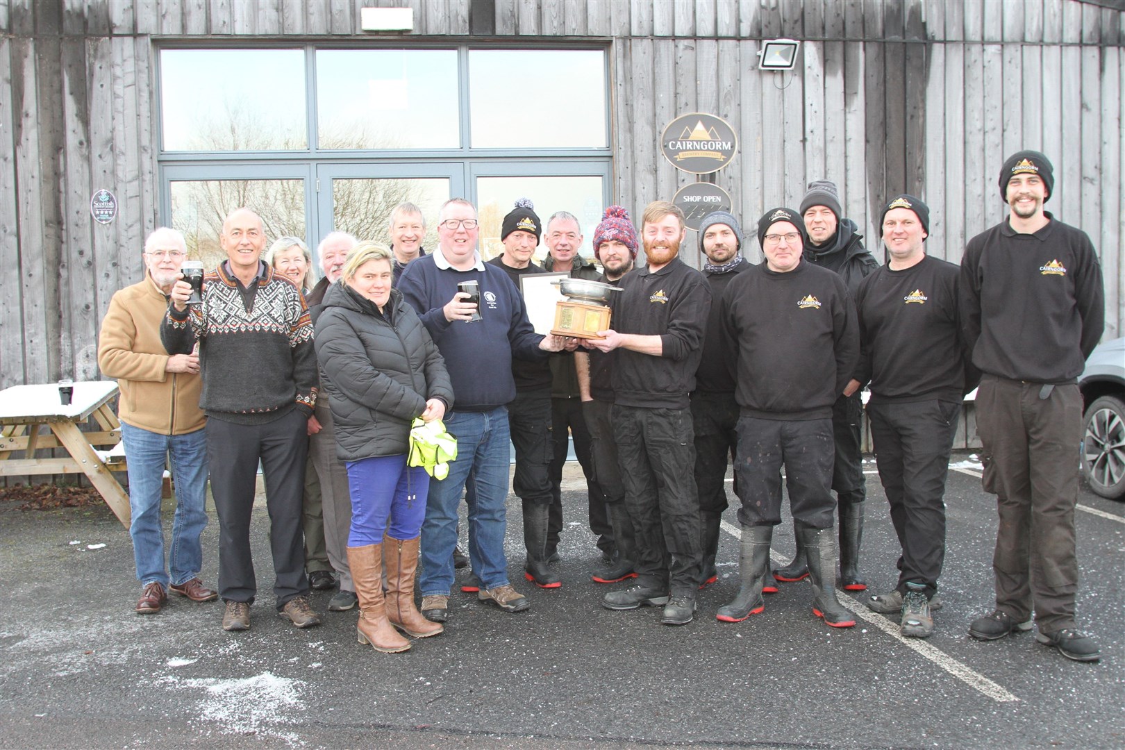 Brewer Liam Anderson receives the trophy on behalf of the team from CAMRA regional director for Scotland Stuart McMahon (centre, with beer).