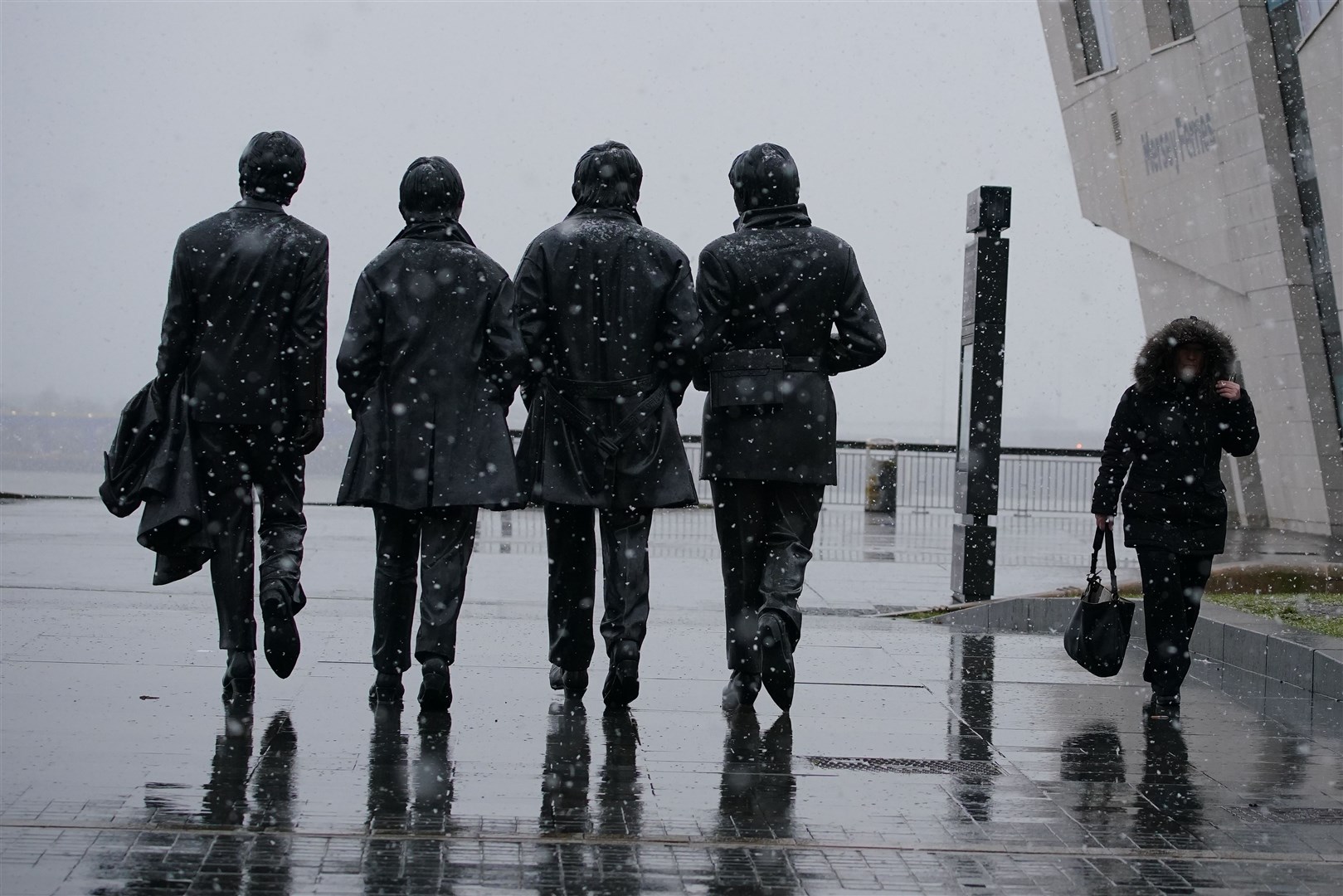Not far way in the city, snow was falling at the Beatles statue in Liverpool (Peter Byrne/PA)