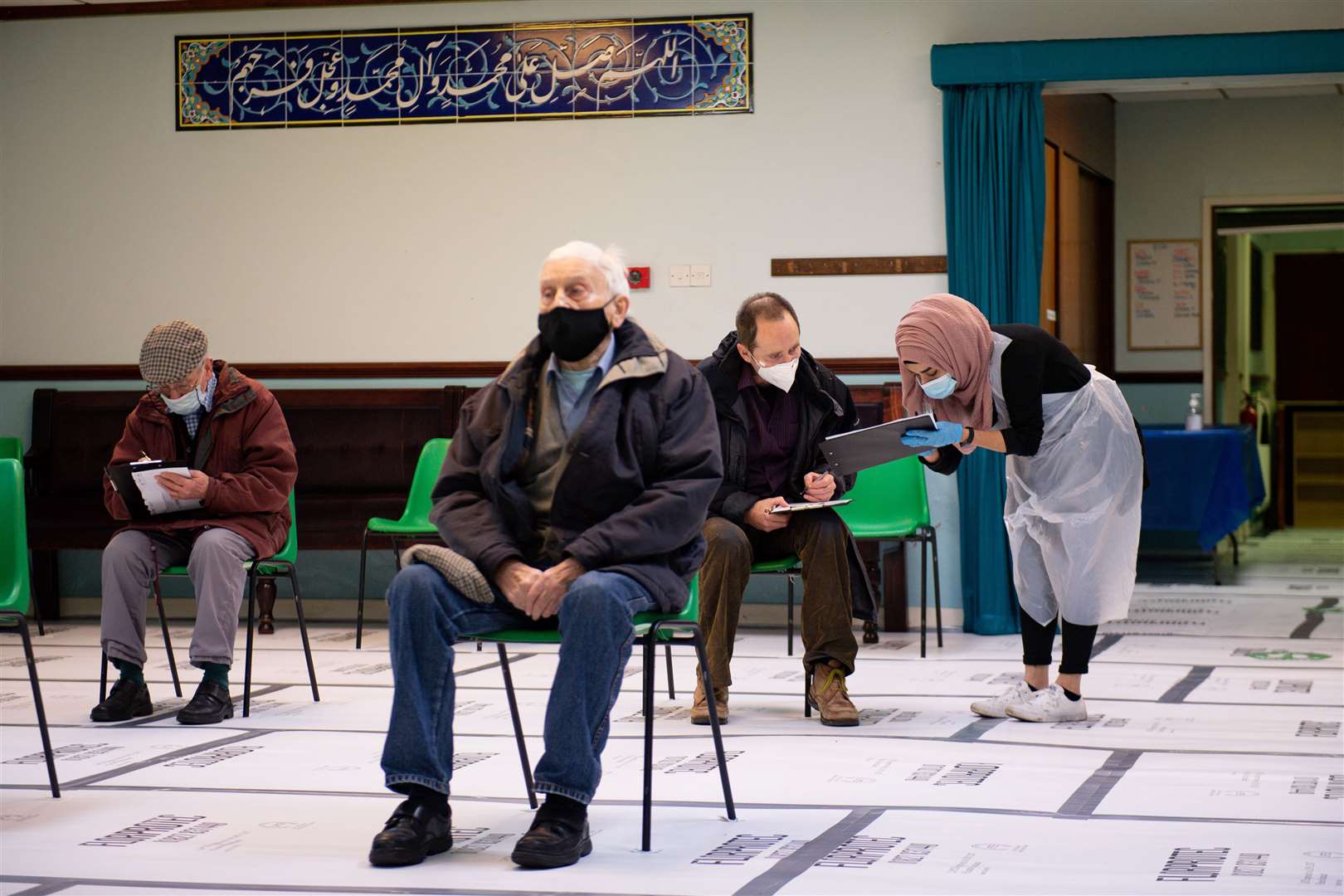 Patients including 89-year-old Sylvester O’Neill in a waiting area at the mosque (Jacob King/PA)