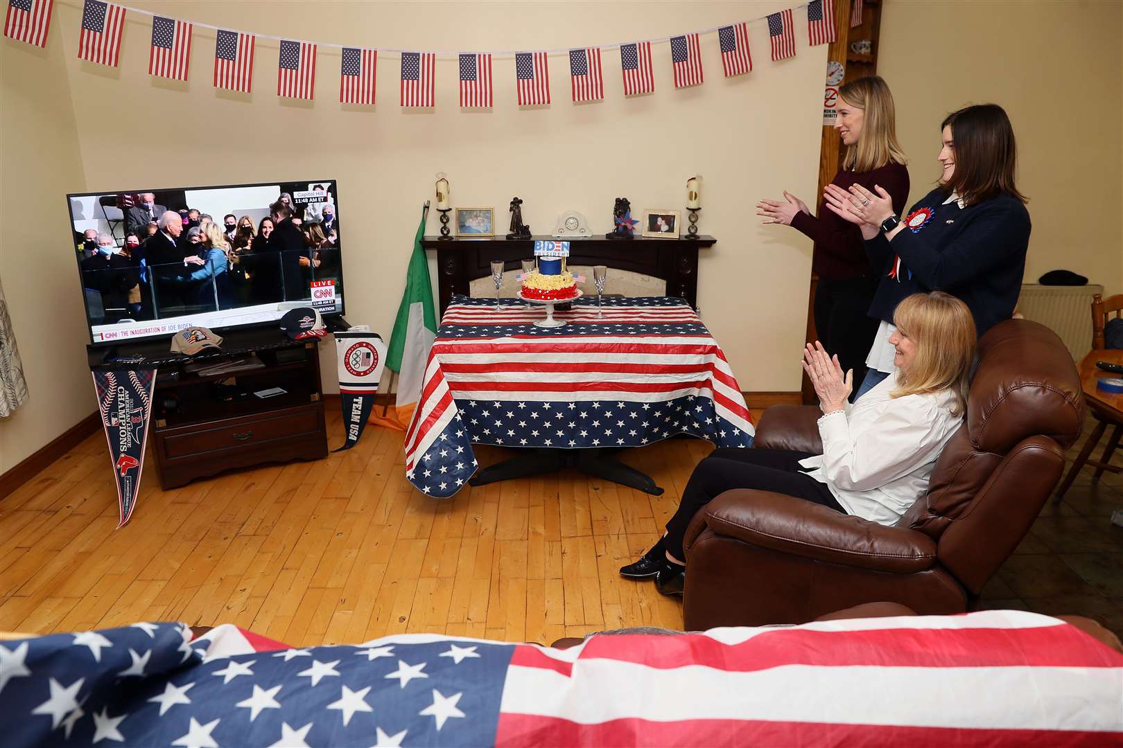Fourth cousin of President Joe Biden, Veronica McKevitt (sitting) and her daughters Councillor Andrea McKevitt (right) and her sister Ciara, applaud Mr Biden at their home on the Cooley Peninsula (Brian Lawless/PA)