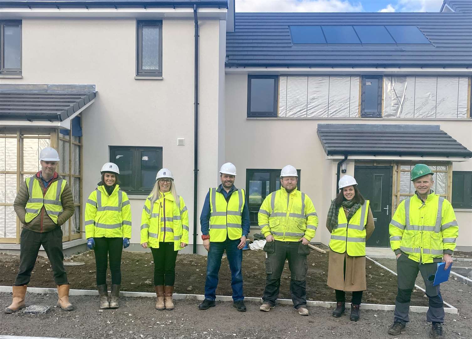 Some of those involved in the project – including Mark Tate (centre) gathered at the homes in Aviemore as they took shape towards the end of last year.