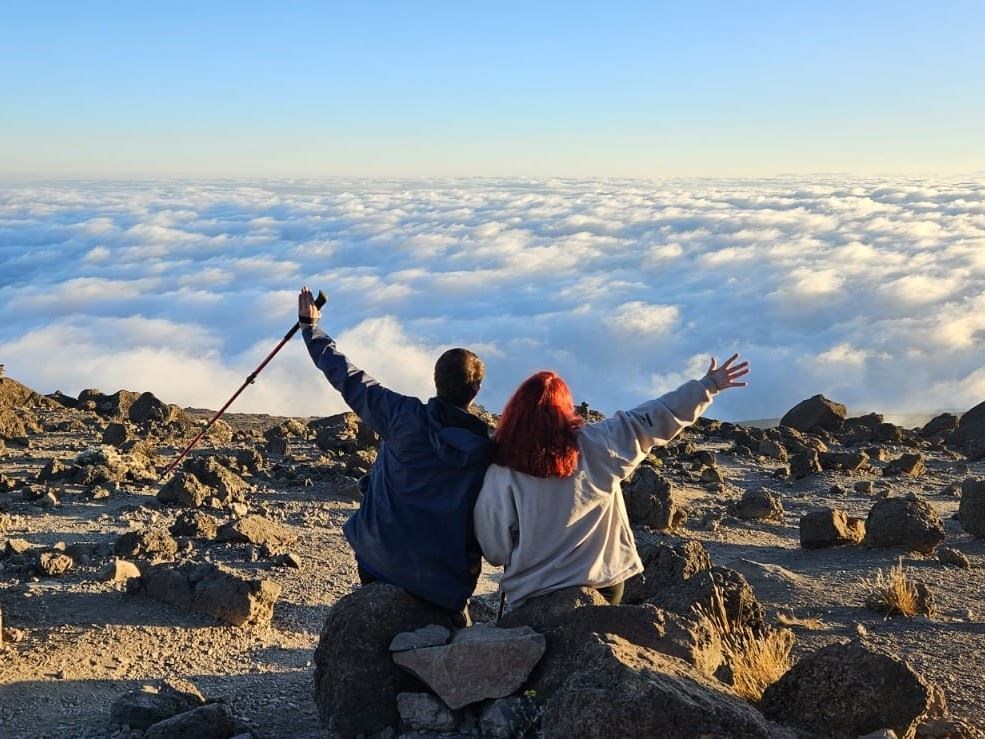 Ms Brady and her father Sean, look out over the clouds from the summit of Mount Kilimanjaro (The Highest Harp Concert Team/PA)