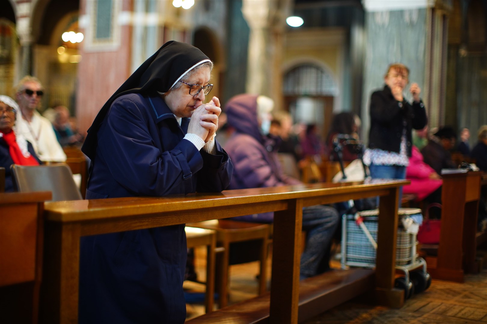 A nun prays in Westminster Cathedral in central London following the announcement of the death of Pope Francis (James Manning/PA)