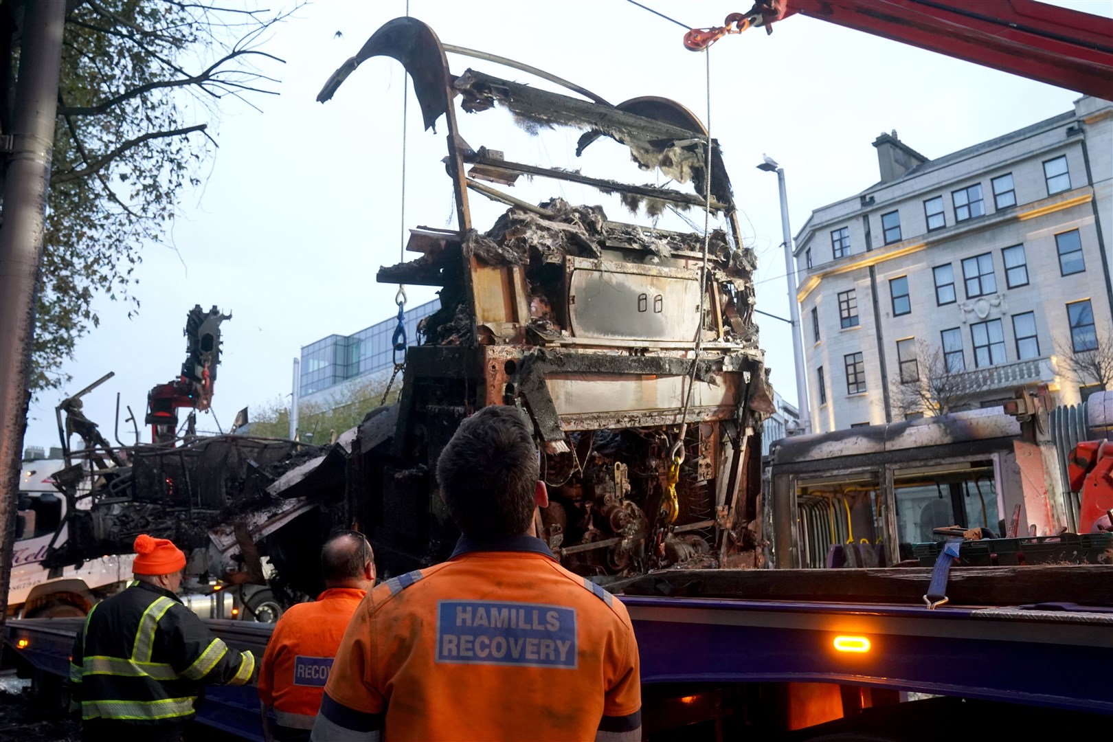 A burned out bus is removed from O’Connell Street in Dublin, in the aftermath of violent scenes in the city centre (Brian Lawless/PA)