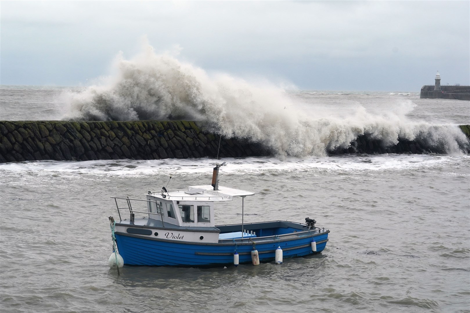 Waves crash behind a fishing boat at Folkestone harbour (Gareth Fuller/PA)