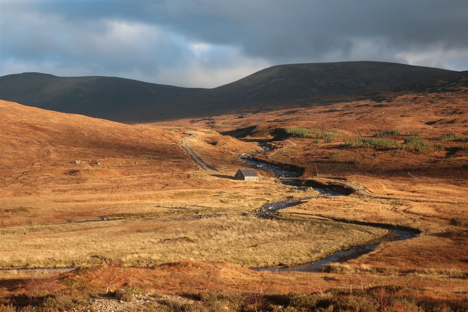 The sun lights up the Uisge Labhair which leads to the Bealach Dubh below Ben Alder.