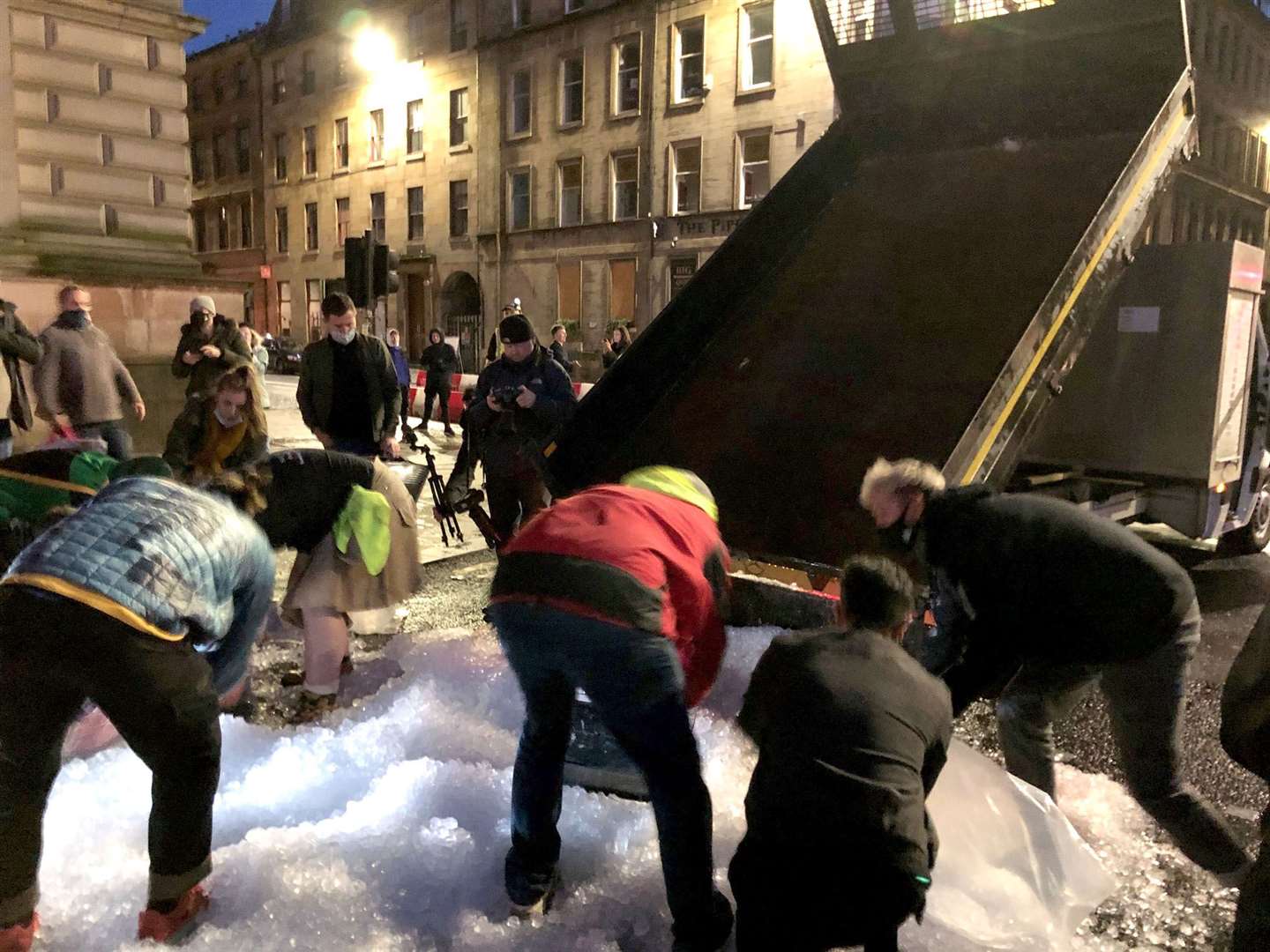 A truck dumped ice at the corner of George Square and was transported to the main pile by buckets, bags and jackets (Douglas Barrie/PA)