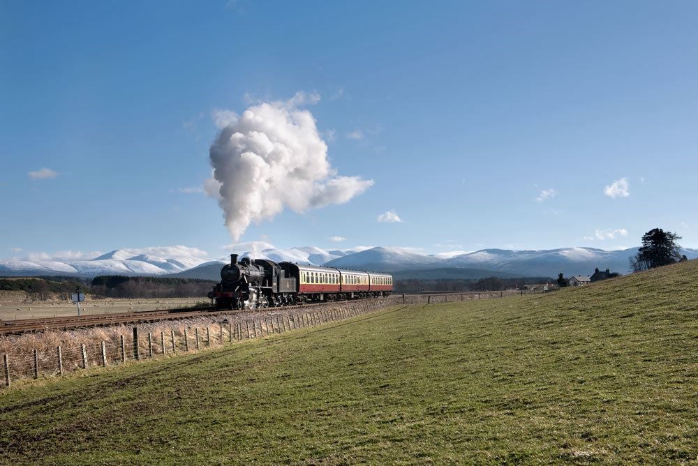 Let the train take the strain.... one of the Strathspey steam railway services on its way from Aviemore to Broomhill by Dulnain Bridge with the snowcapped Cairngorms in the background.