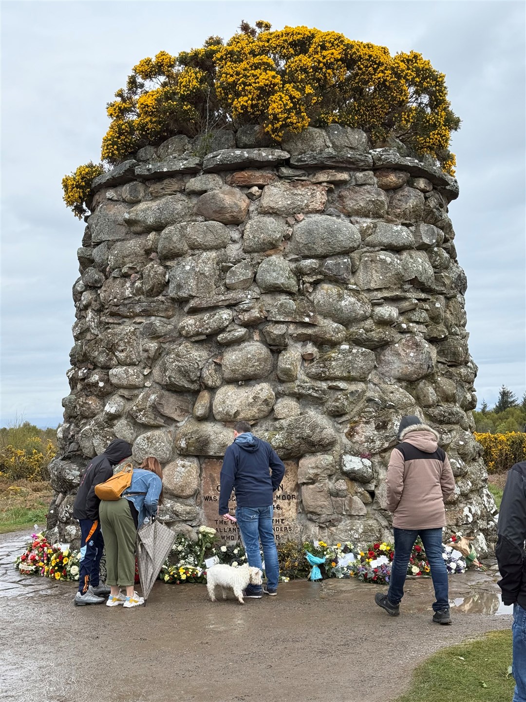 Visitors to the cairn looking at some of the tributes following the service.