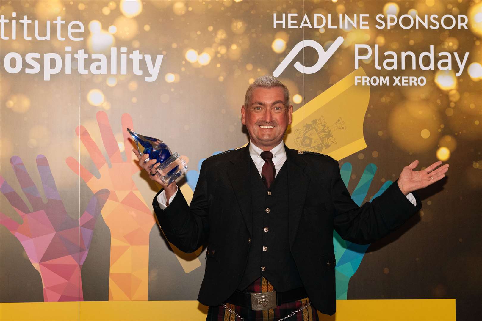 Inverness airport general manger Graeme Bell celebrates after receiving the Hospitality Assured award for excellence in customer service. (Picture from Hospitality Assured).