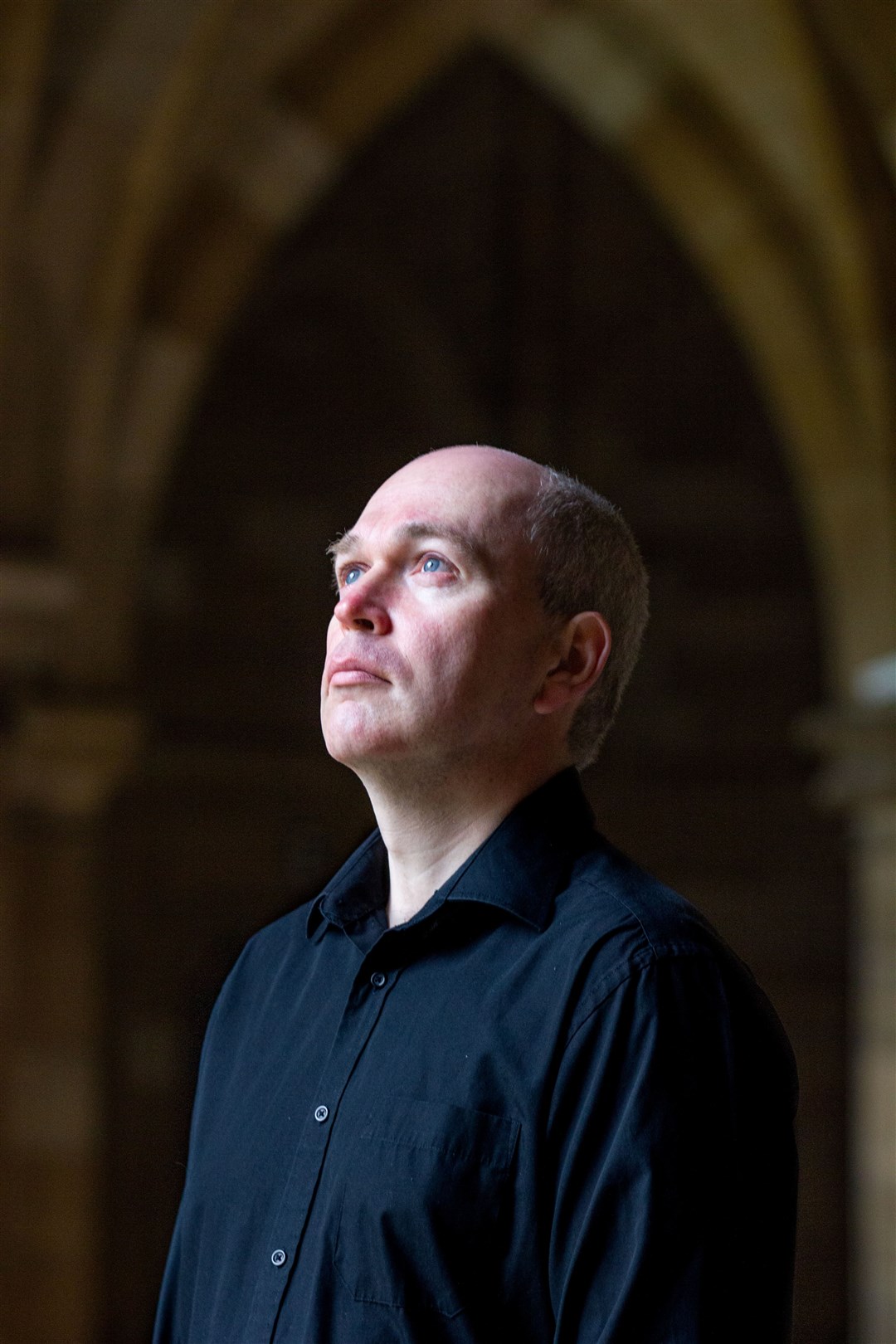 Lecturer Gillebride MacMillan who played Gwyllynthe Bard in the first series of Outlander in the Cloisters at the University which was used as a location in the third series.