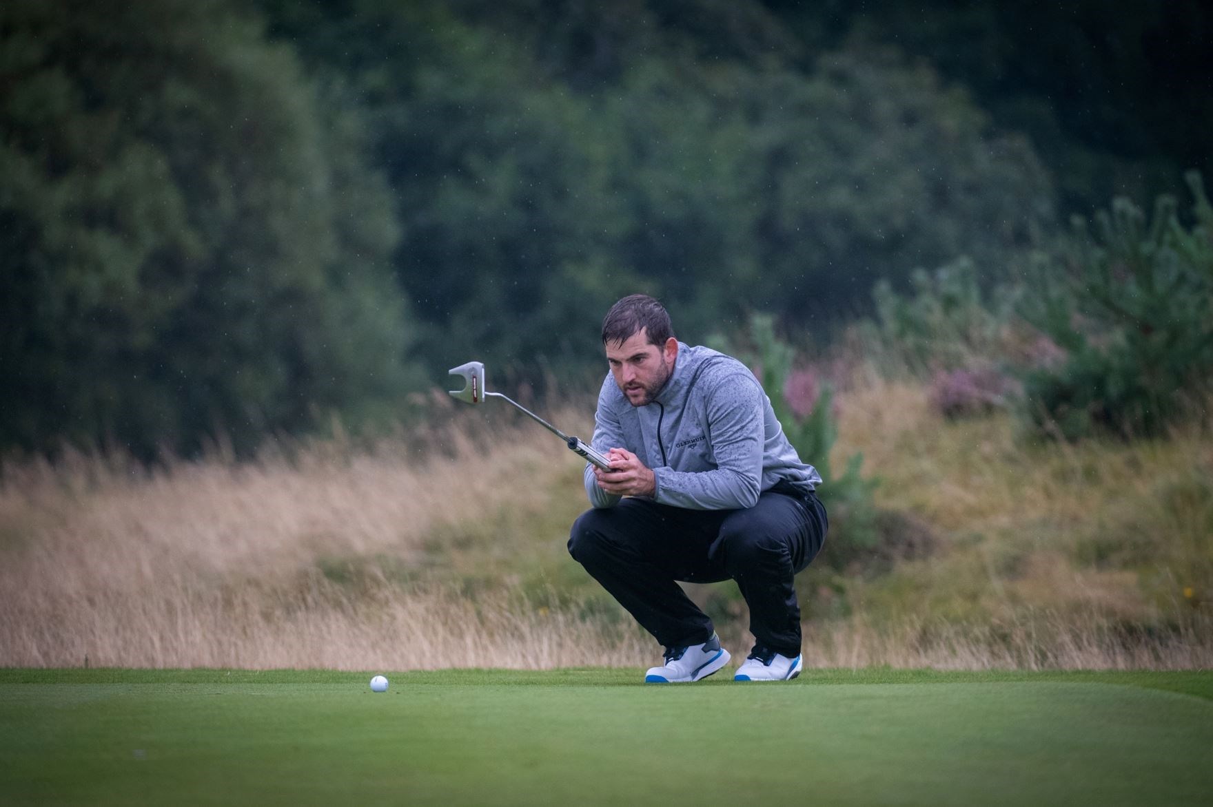 Weighing up a putt in the drizzle.