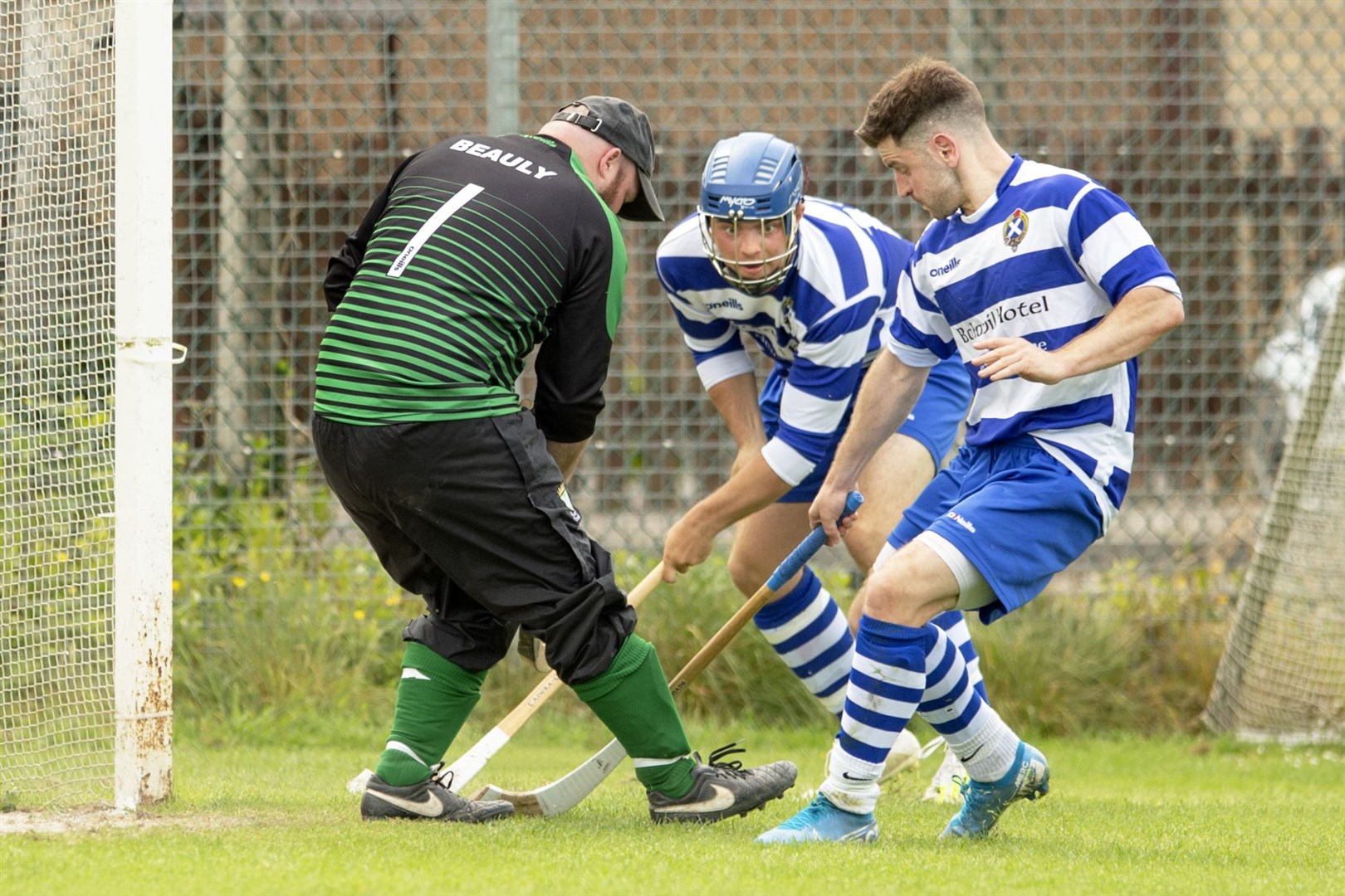 Newtonmore duo Iain Robinson (centre) and Drew Macdonald put pressure on Beauly keeper Mackay Murray. Beauly v Newtonmore, in the Mowi Senior League B. First competitive game back after Covid restrictions.