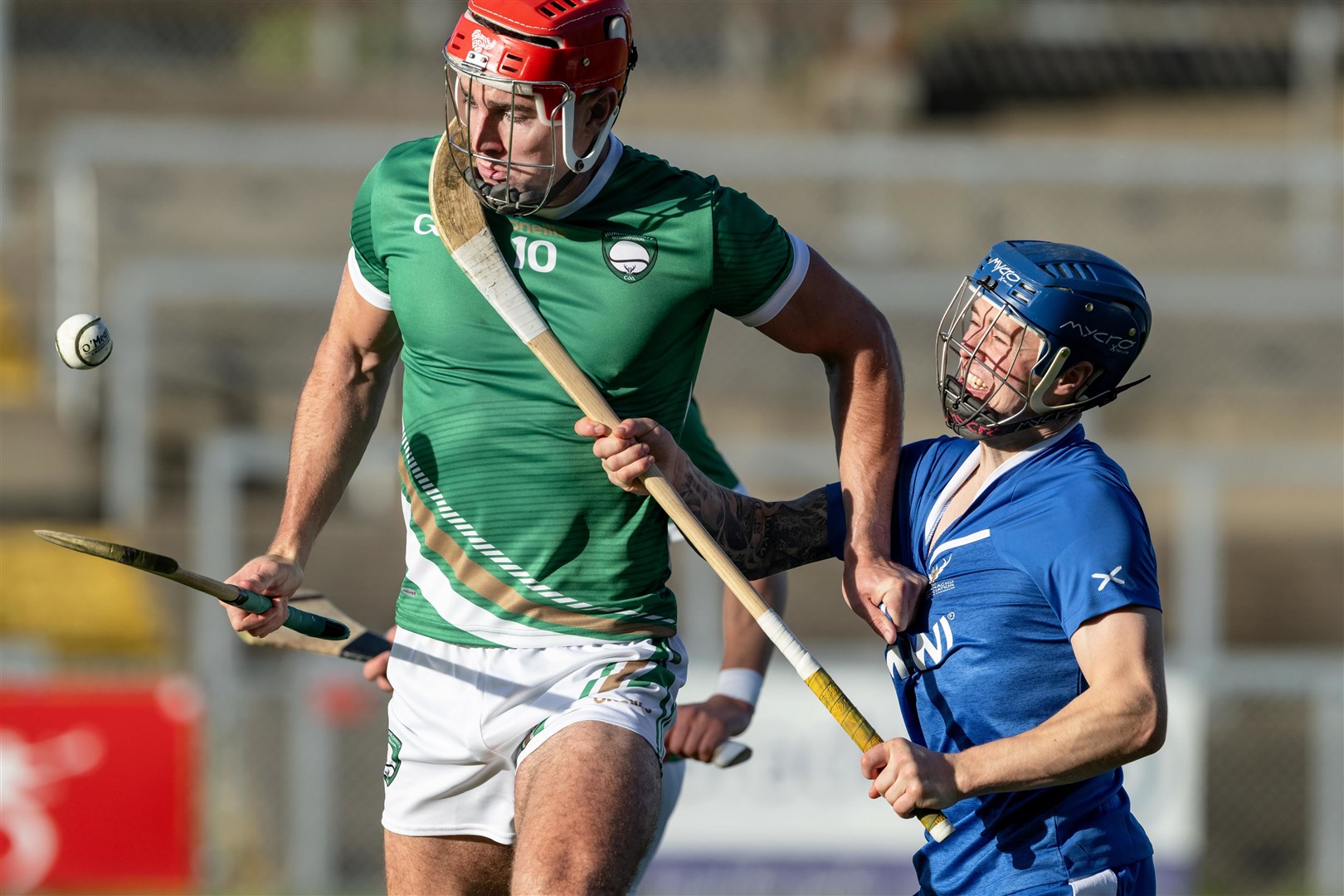 Ireland's Fionan MacKessy with James Falconer (Kingussie). Ireland v Scotland shinty / hurling international, played at Pairc Esler, Newry.