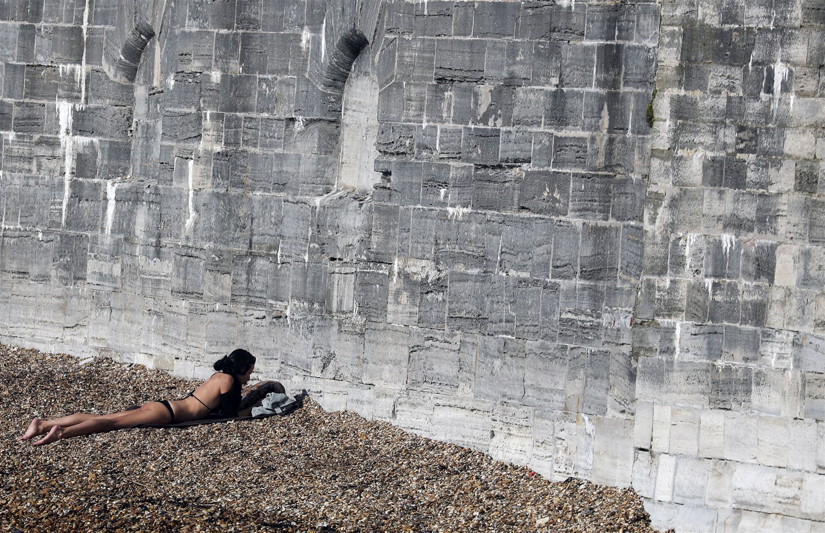 A woman sunbathes in Old Portsmouth, Hampshire (Steve Parsons/PA)