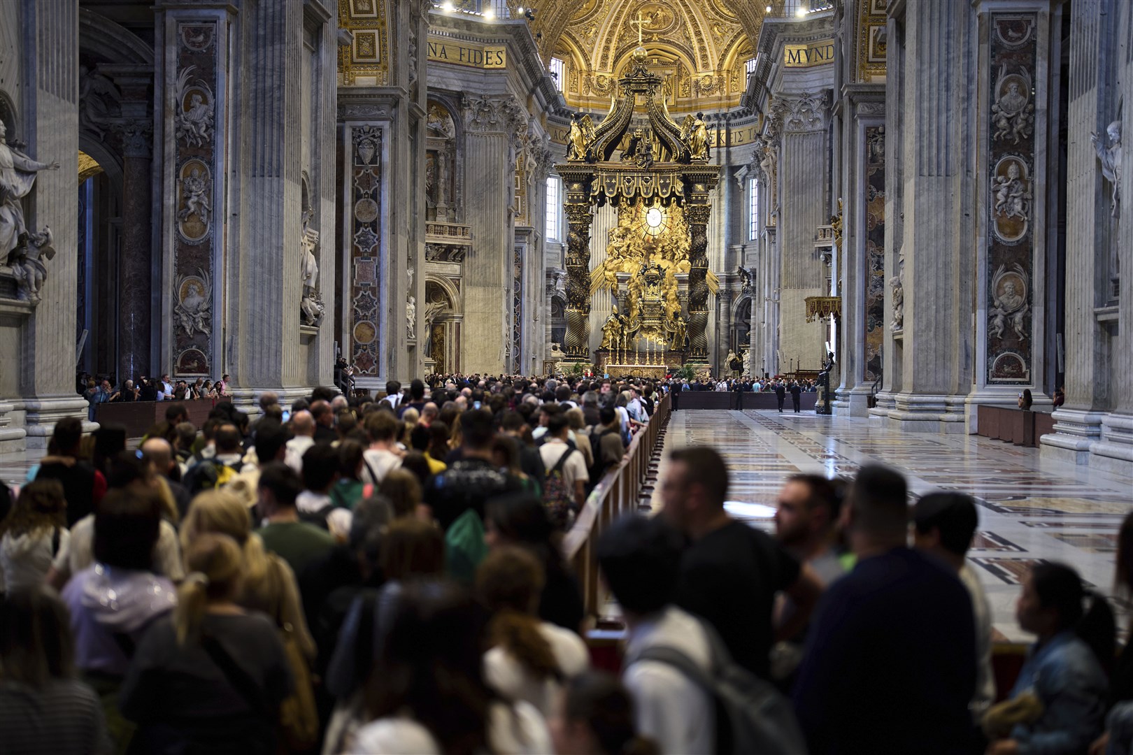 People wait in a line to pay their respects inside St Peter’s Basilica at the Vatican (Domenico Stinellis/AP)