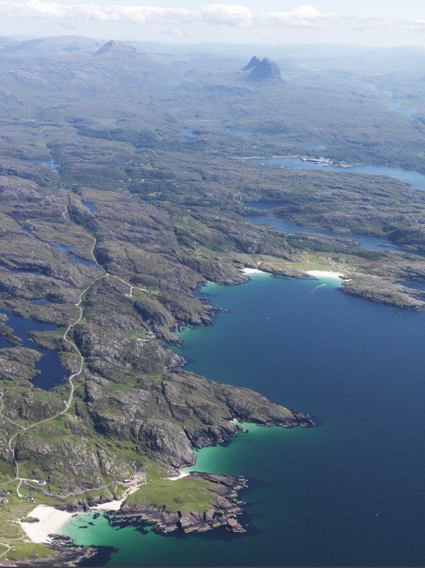 A view looking down the coast with the a' Chlach Thuill dun in the foreground, Lochinver in the middle distance and Canisp and Suilven beyond, Picture: © Crown Copyright: Historic Environment Scotland.