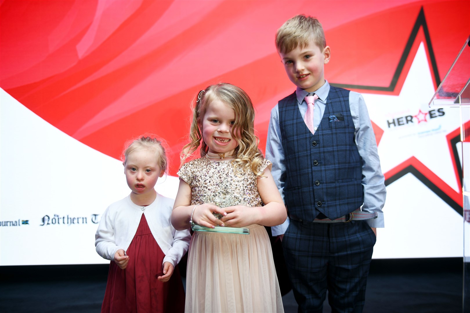Gracie Andrew (centre) won the brave child award and invited fellow finalists Gracey Wemyss and Alfie Ross onto the stage. Picture: James Mackenzie