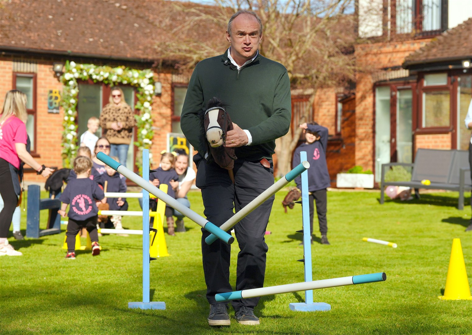 Sir Ed Davey smashed through a blue fence on a hobby horse as he launched the Lib Dem local election campaign (Jonathan Brady/PA)