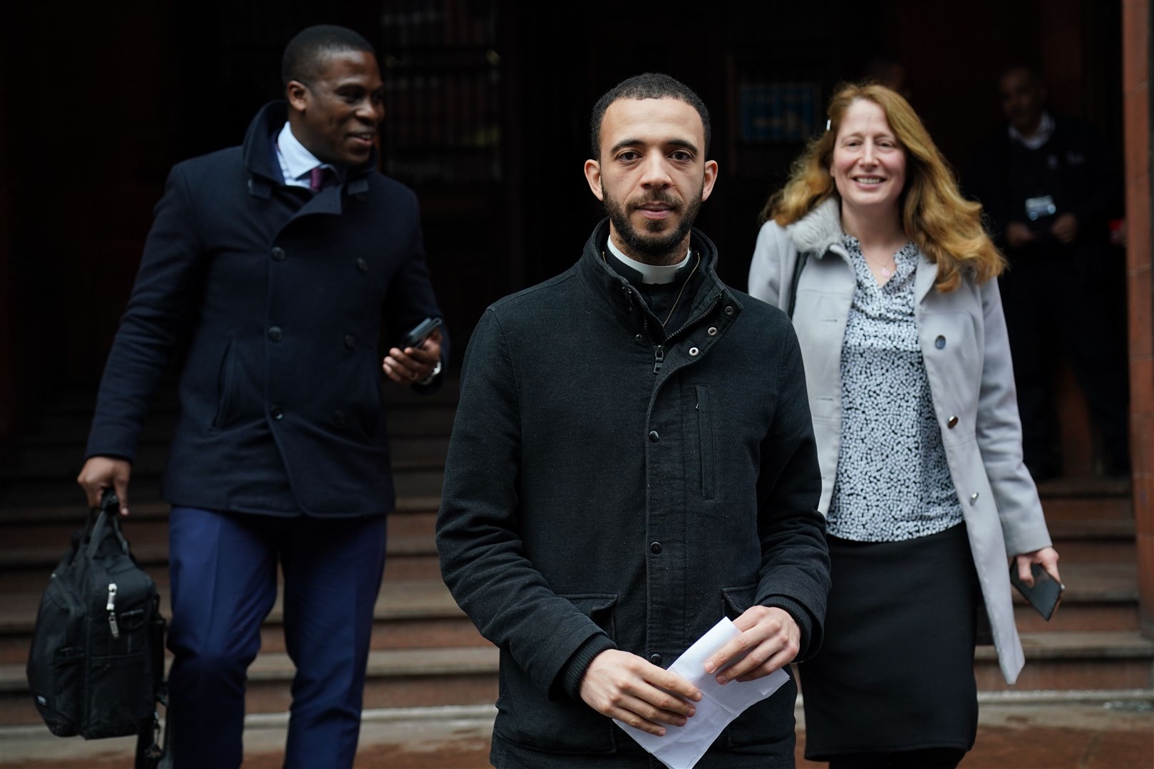 Fr Sean Gough (centre) leaves court with Isabel Vaughan-Spruce (Jacob King/PA)