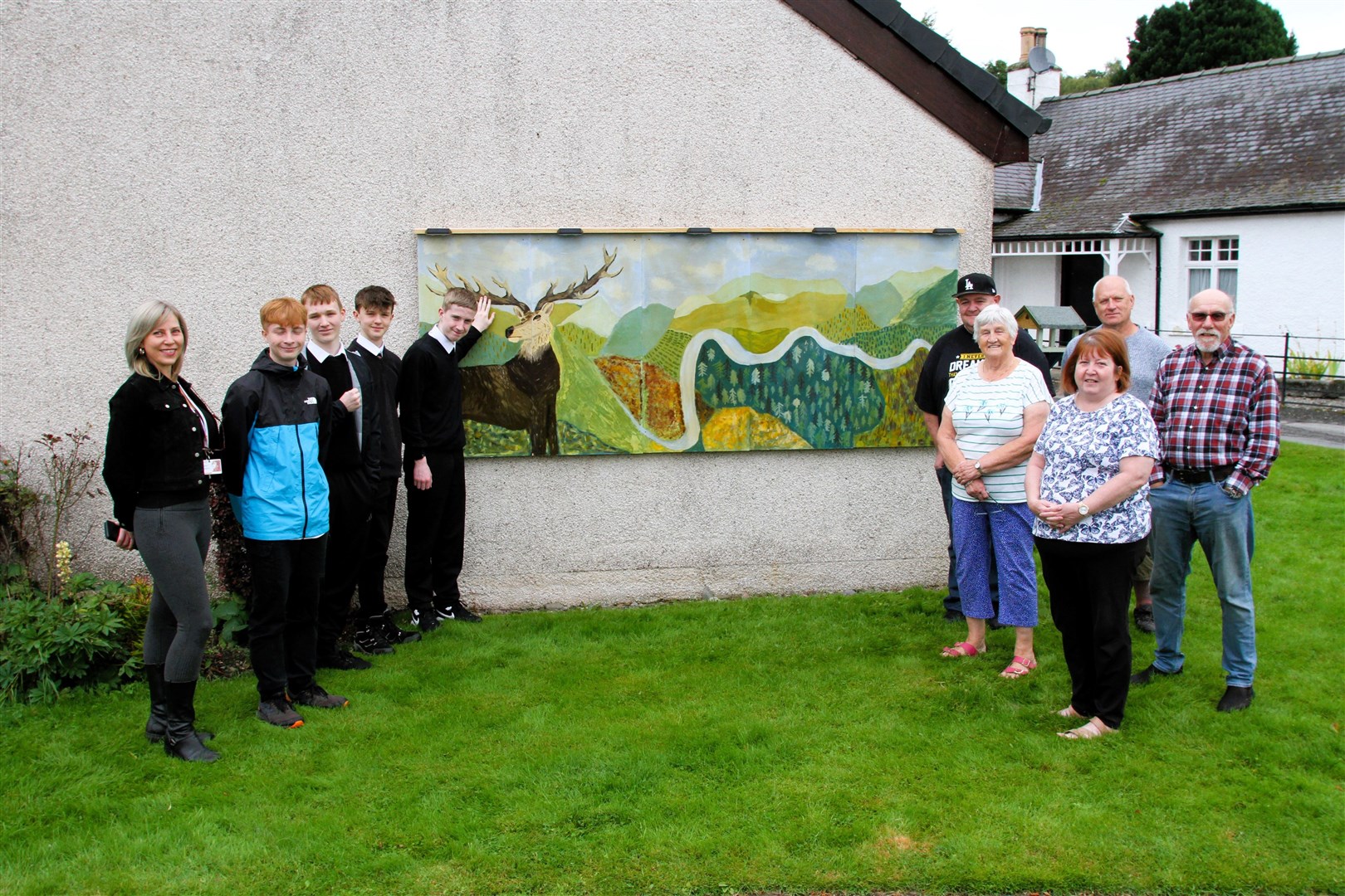 Hanover Housing official Mia Calder with artists Connor Clark, Brodie Inglis, Rafi Amran and Archie Mackellaig, on the right are Glen Growers David Warner, Ian Macpherson, Angela Macpherson, Janet McLean and Gordon Lennox.