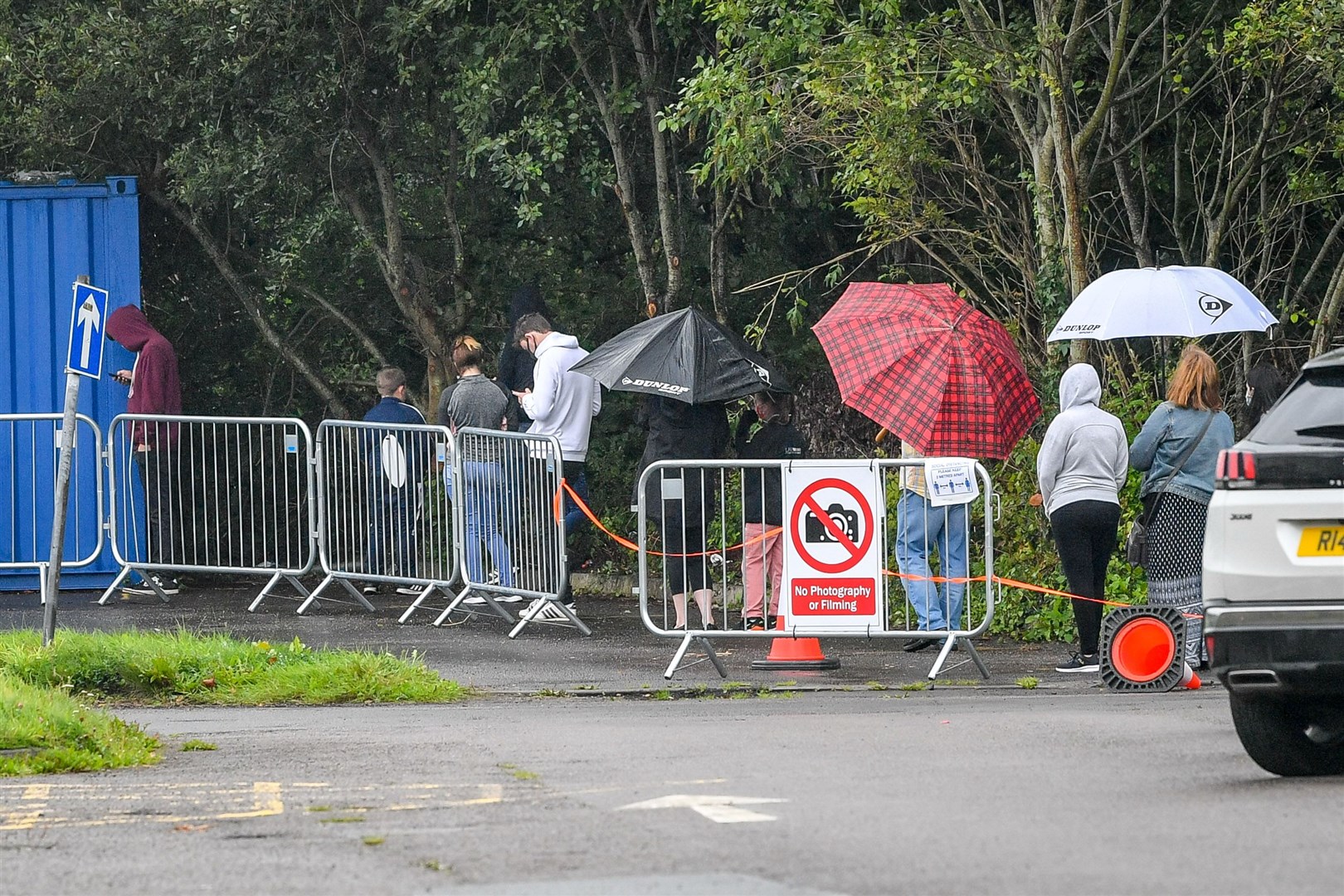 People wait in a long queue to access the walk-up coronavirus testing centre at Caerphilly Leisure Centre (Ben Birchall/PA)