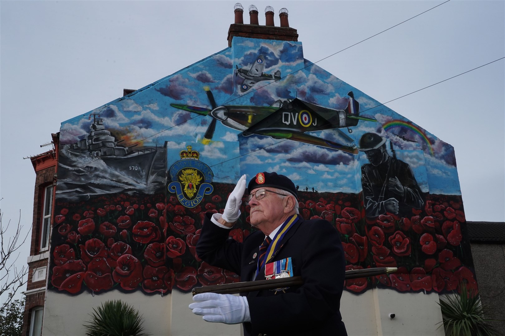 Eric Howden BEM, 76, chairman of the Redcar British Legion who served with the Royal Ordnance Corps, in front of a commemorative war mural in Redcar (Owen Humphreys/PA)