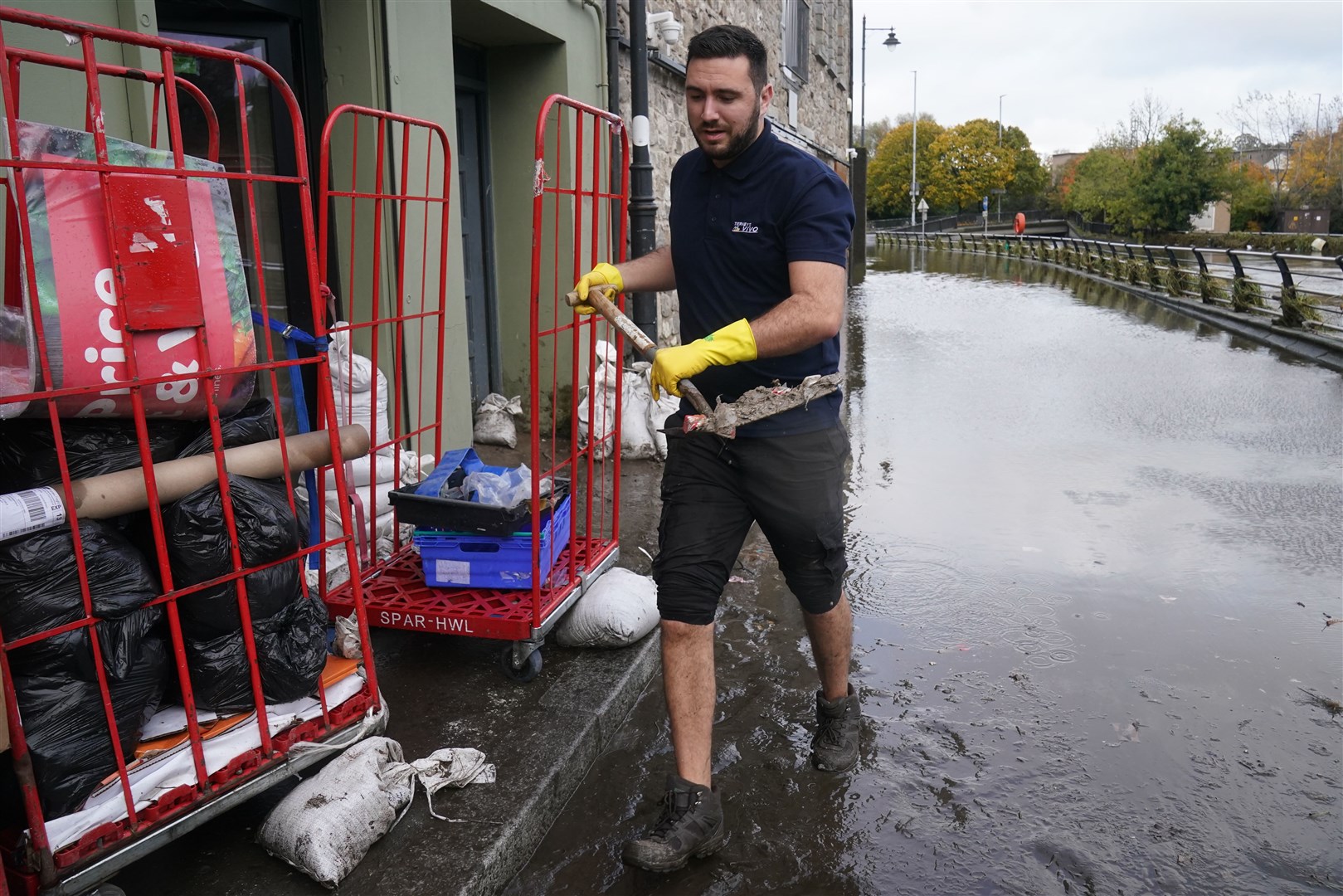 Ross Campbell, sales assistant at Vivo, clears out damaged property in Newry Town (Brian Lawless/PA)