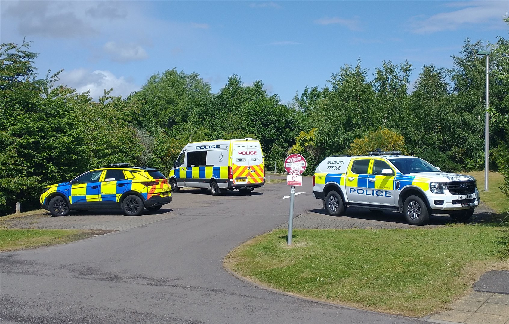 Police vehicles at a car park near Inshes Park.
