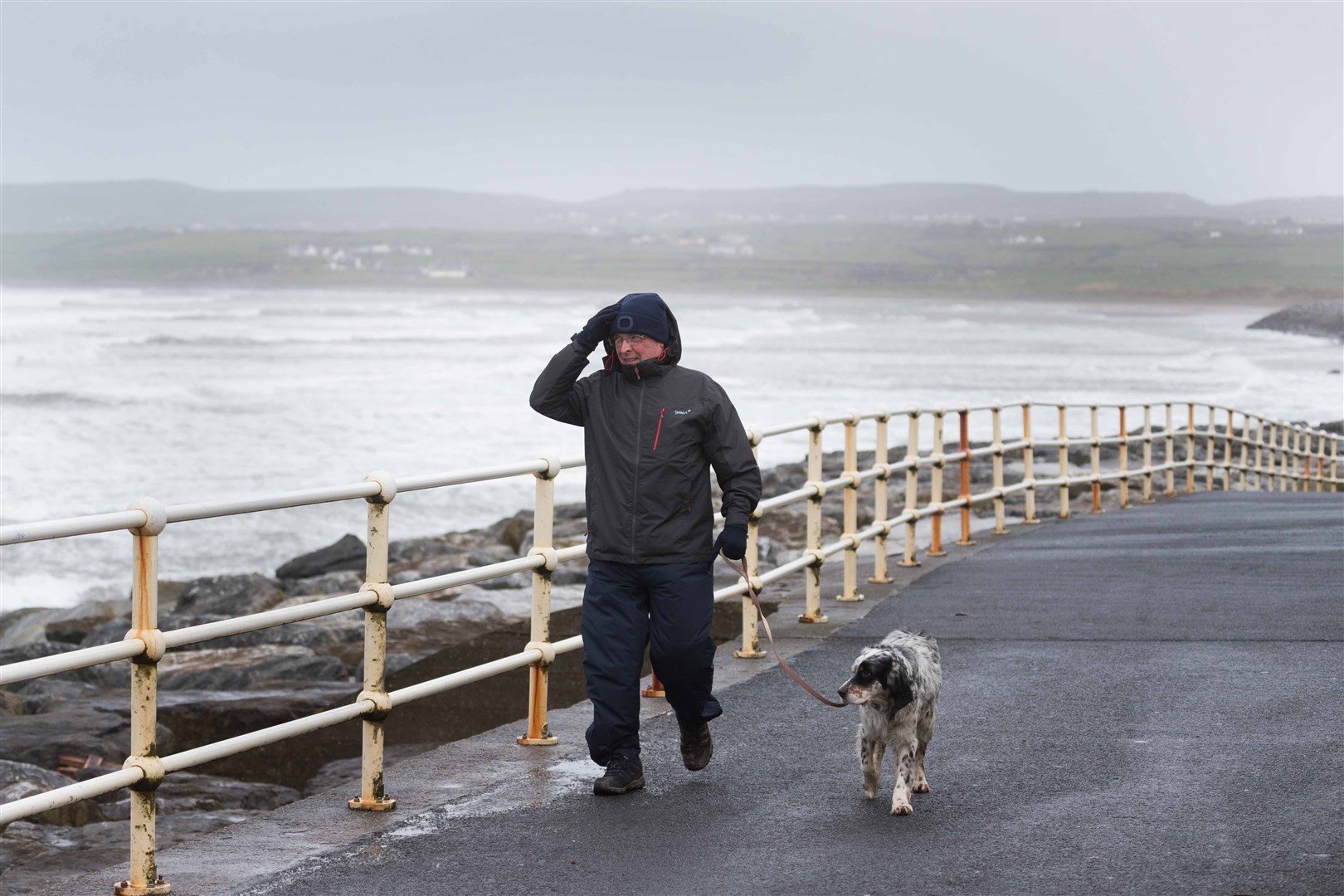 Seamus Rockett with dog Sam out for a walk along the promenade in Lahinch, Co Clare on Friday (Eamon Ward/PA)