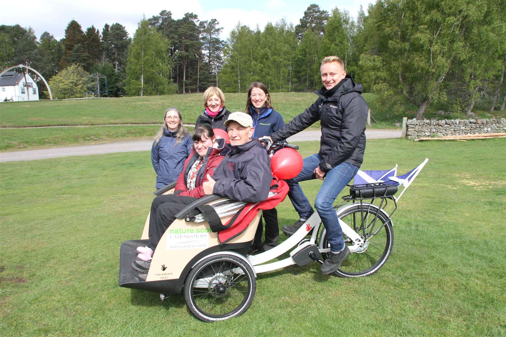 A TRICYCLE MADE FOR TWO: Chloe Gillings (Caberfeidh House) and Donnie Grant (Shinty Memories) seated while looking on are Gaynor Rodger (CNPA), Maggie Lawson (BSCTC), Debbie Greene (SNH) and pilot David Clyne (CNPA).