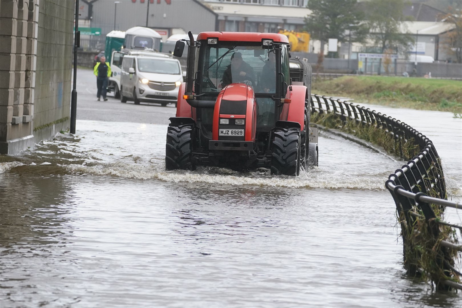 A tractor makes its way through flood water in Canal Quay in Newry (Brian Lawless/PA)