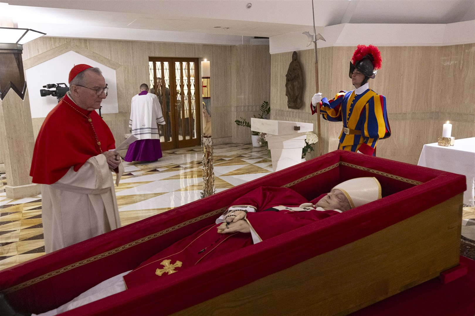 Vatican secretary of state Cardinal Pietro Parolin prays in front of the body of Pope Francis laid out in state at the Vatican (Vatican Media via AP)