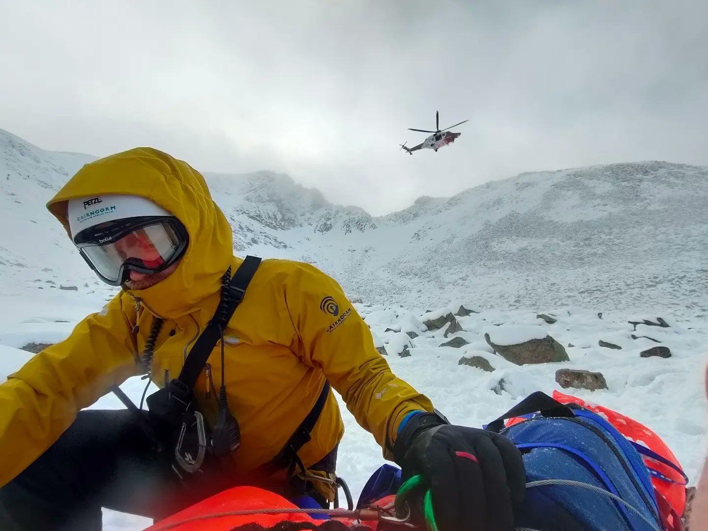 A member of the CMRT at the scene of the climbing accident on Saturday with the Coastguard helicopter in the background.